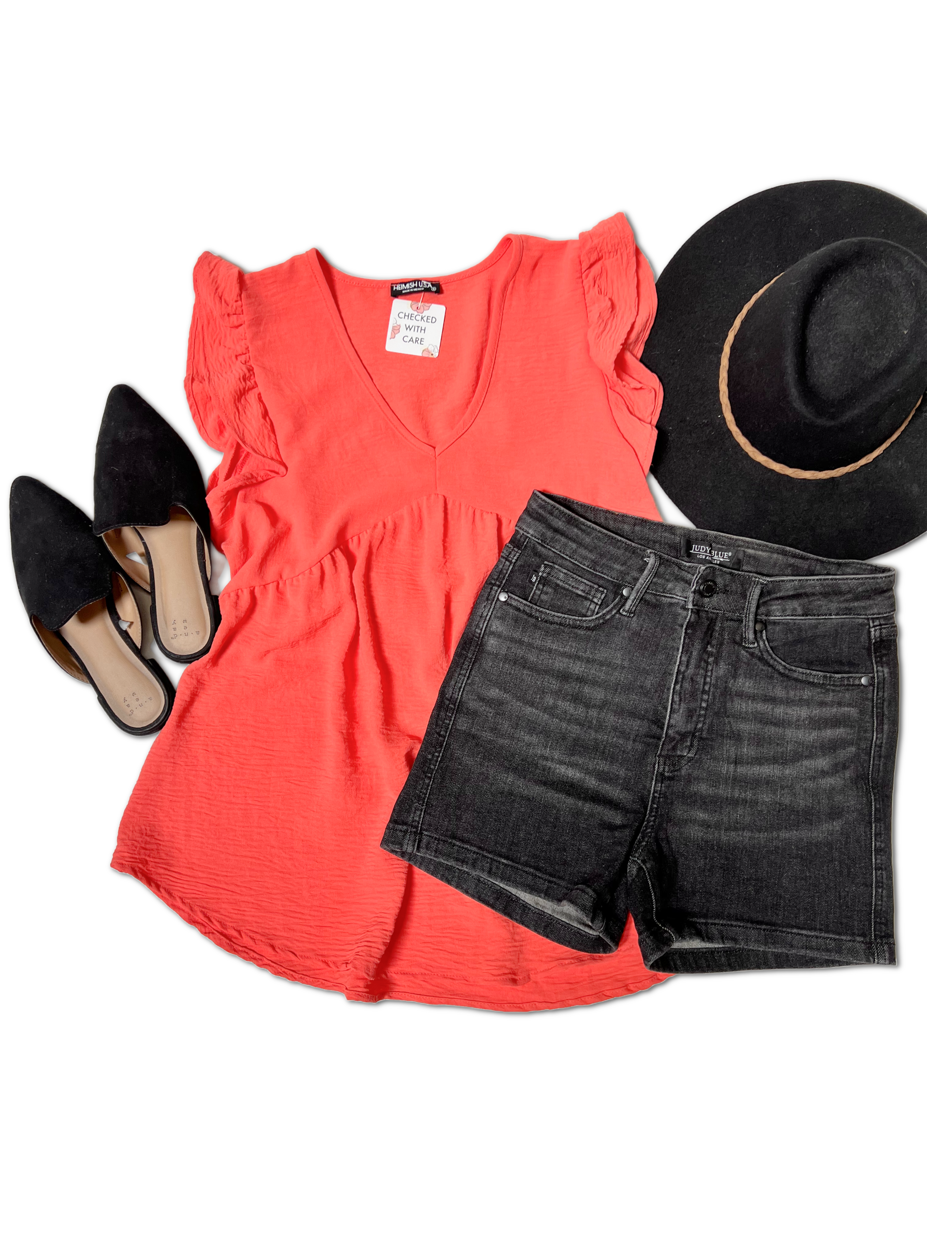 A flat lay of a casual outfit featuring the Heimish Feel The Flutter - Top with butterfly short sleeves in bright coral, dark gray denim shorts, a black wide-brim hat with a tan band, and black suede pointed-toe flats.