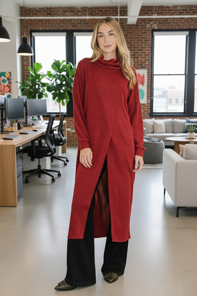 Woman wearing a long red dress standing indoors with a plant in the background