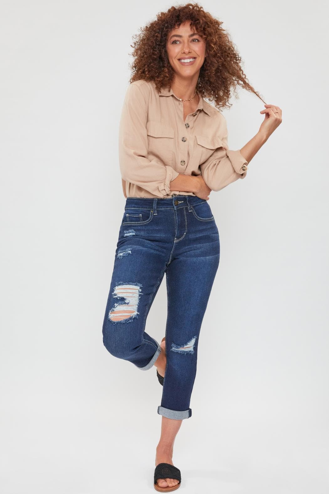 Woman wearing a beige jacket and blue jeans on a white background