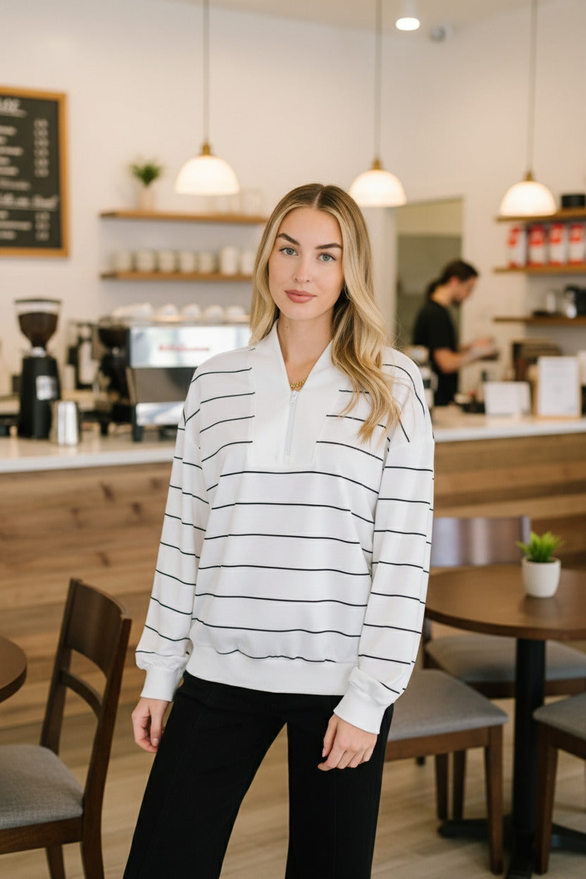Woman wearing a white and black striped shirt in an indoor setting